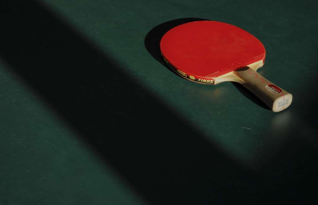 Table tennis bat on green table