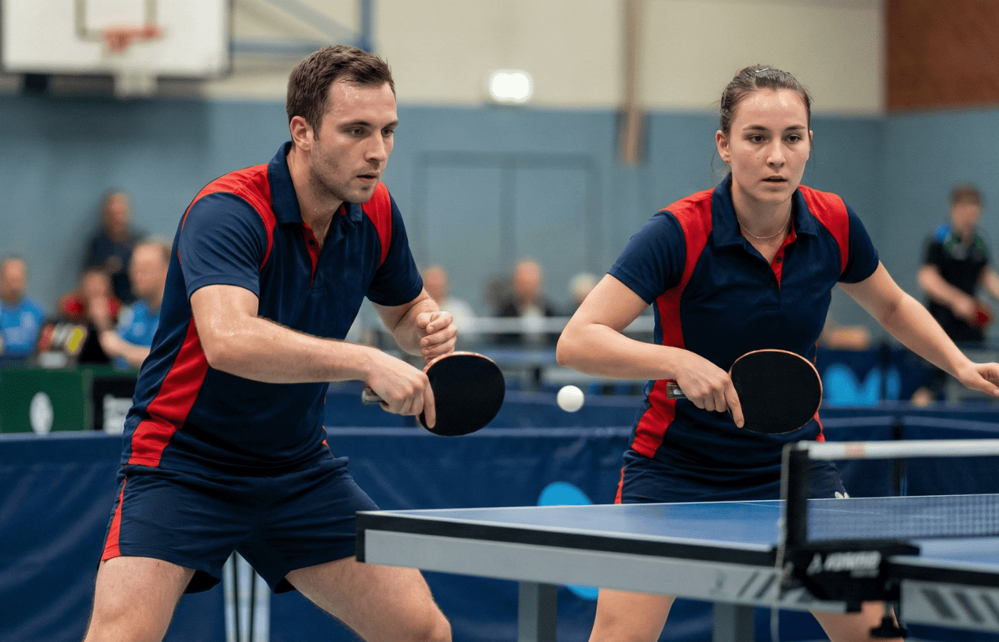 A pair of table tennis pros in matching uniforms.
