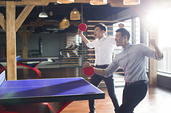 Young Chinese businessmen playing ping pong